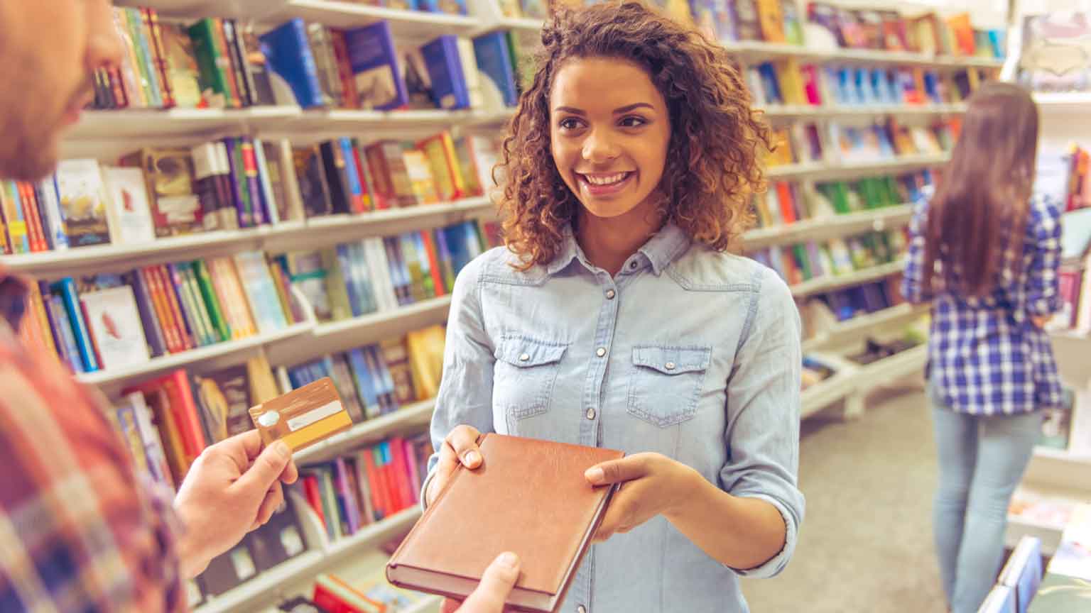 student buying book at the bookshop using a credit card