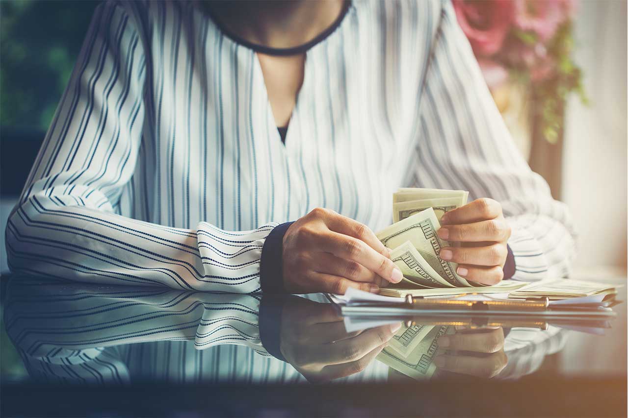 Woman with money on desk